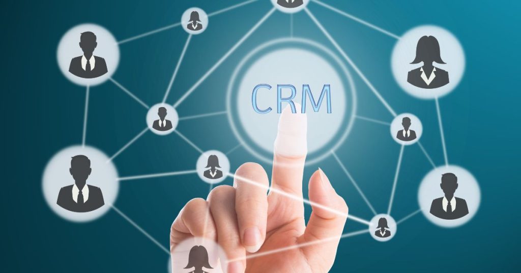 Finger touching the CRM hub amid a network of interconnected user icons representing contacts in a CRM system.