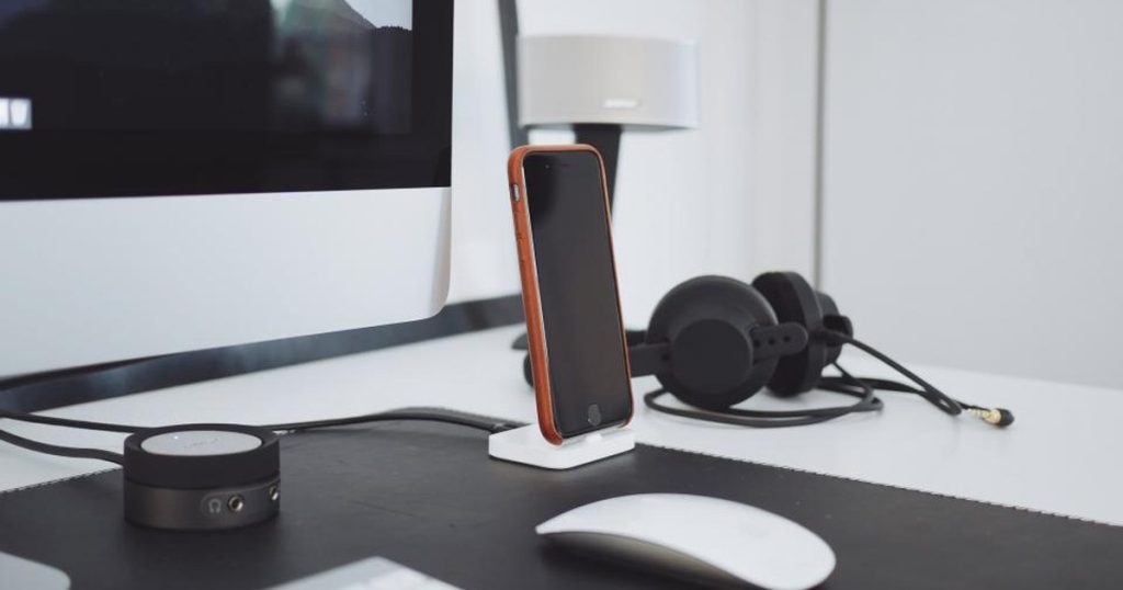 Desk with a smartphone, headset, and computer set up for softphone calling